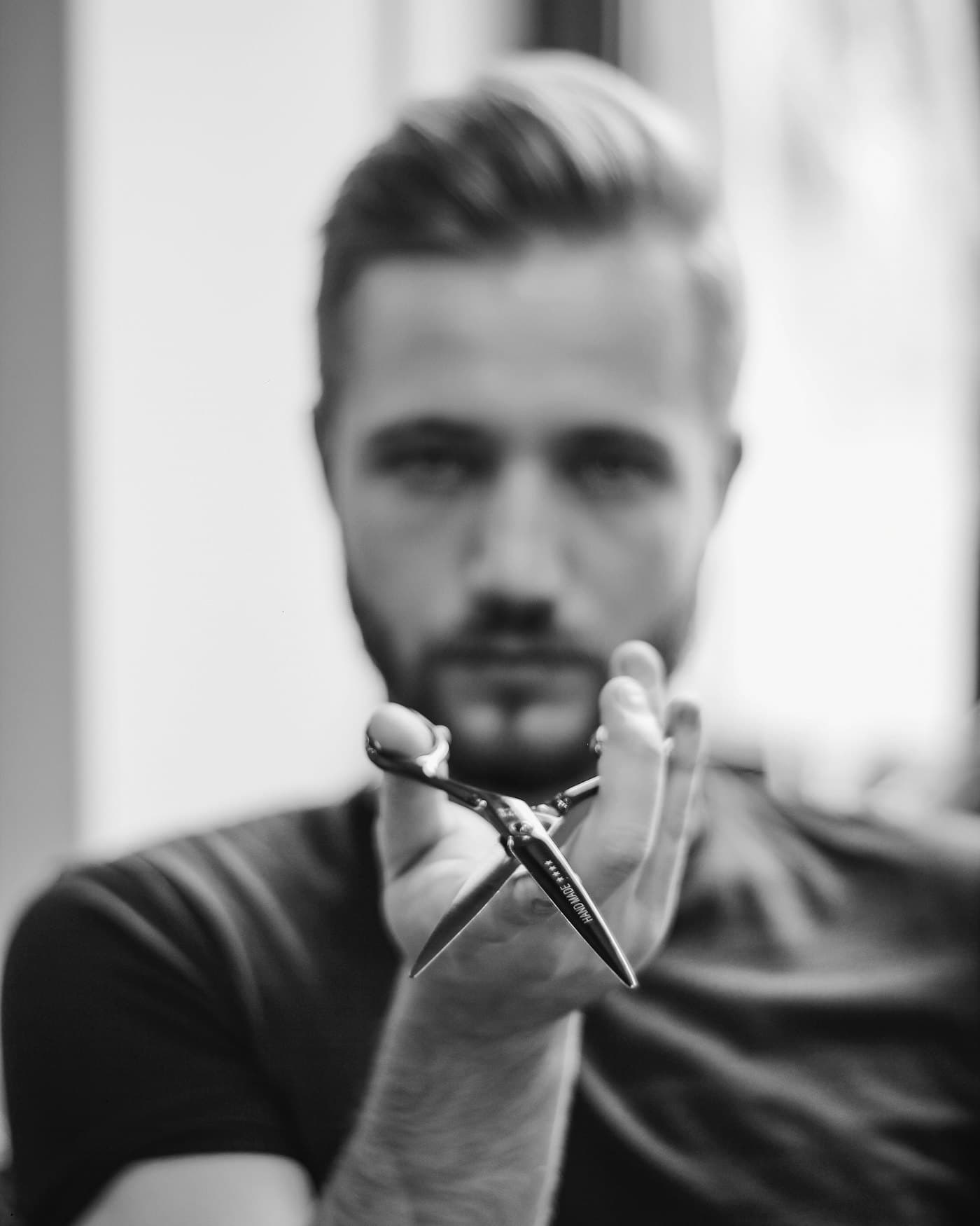 Stylist hält eine Schere in die Kamera